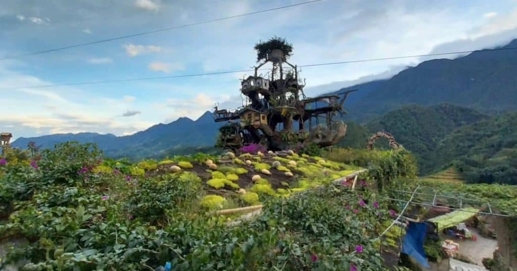 Hmong village scene with lush greenery and traditional houses in Sapa.