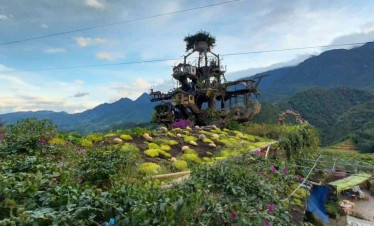 Hmong village scene with lush greenery and traditional houses in Sapa.