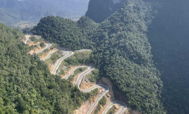 Mountain road winding through lush green mountains in Sapa, Vietnam.