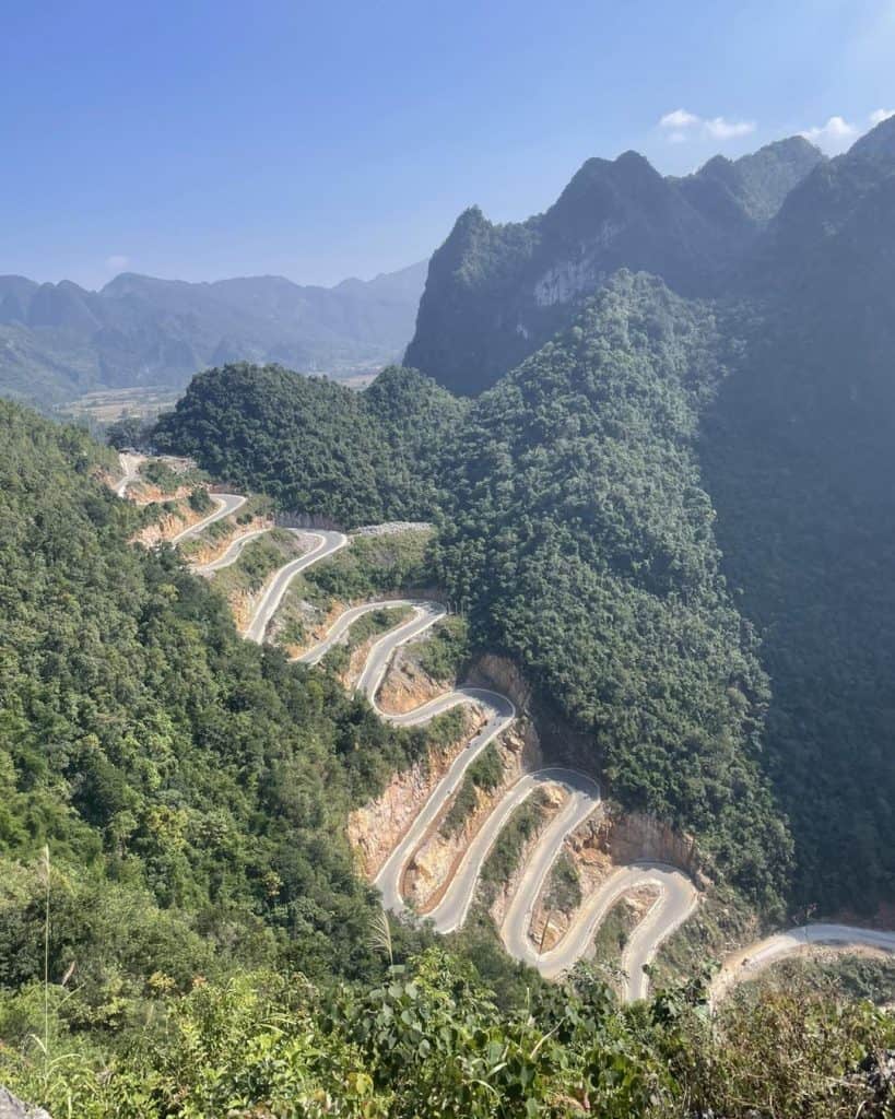 Mountain road winding through lush green mountains in Sapa, Vietnam.