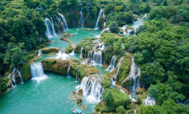 Waterfalls cascading through lush green forest in Northern Vietnam, a breathtaking natural wonder.