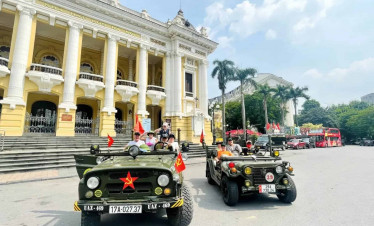 Hanoi city sightseeing in vintage jeeps with vibrant street views and historic architecture.