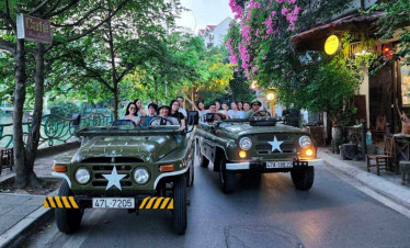 Jeep tour through Hanoi streets with tourists enjoying city exploration.