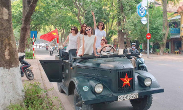 Jeep tour with group of tourists in Hanoi, Vietnam, exploring the city streets.
