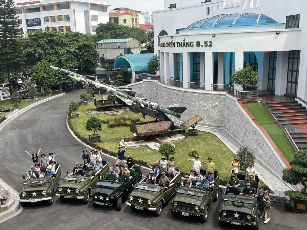 Hanoi jeep tour with vintage vehicles and enthusiastic travelers exploring the city’s historic sites.