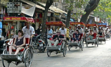 Charming street scene with tourists enjoying Hanoi's vibrant city life on motorbikes and jeeps.