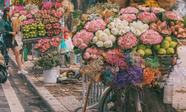 Colorful flower stall on Hanoi street with vibrant blooms and local vendors.