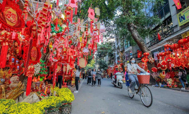Lantern-filled street scene in Hanoi during festive season, vibrant and lively atmosphere.