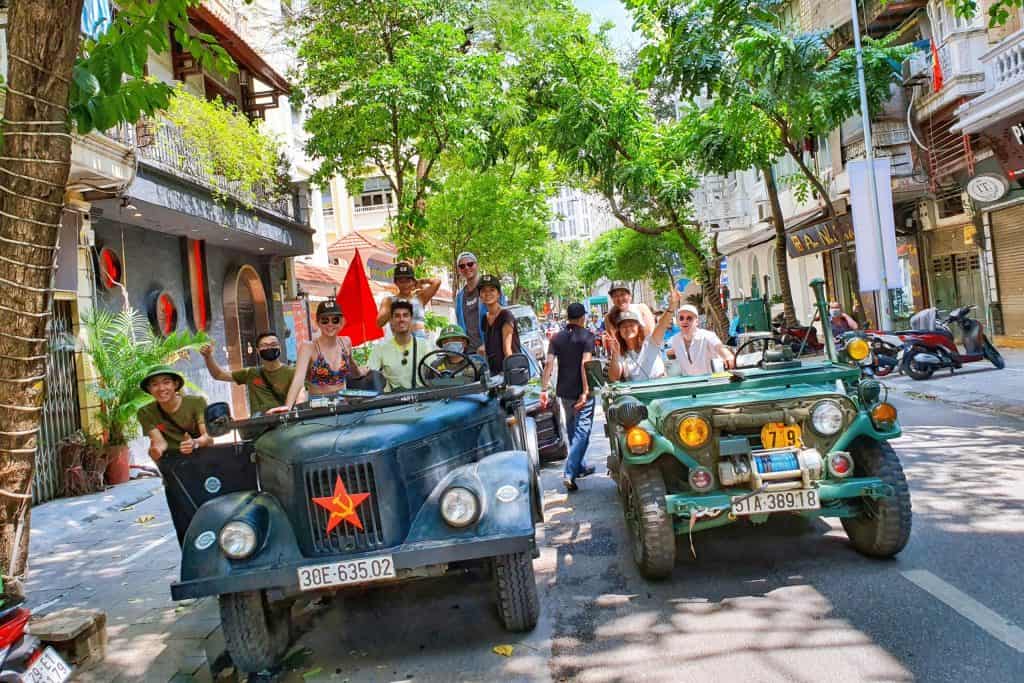 Hanoi city tour with vintage jeeps and motorbikes, exploring vibrant streets and local culture.