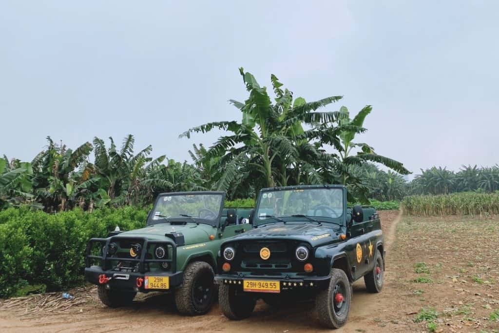 Jeep adventure in Hanoi countryside with banana trees and dirt road.