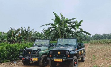 Jeep adventure in Hanoi countryside with banana trees and dirt road.