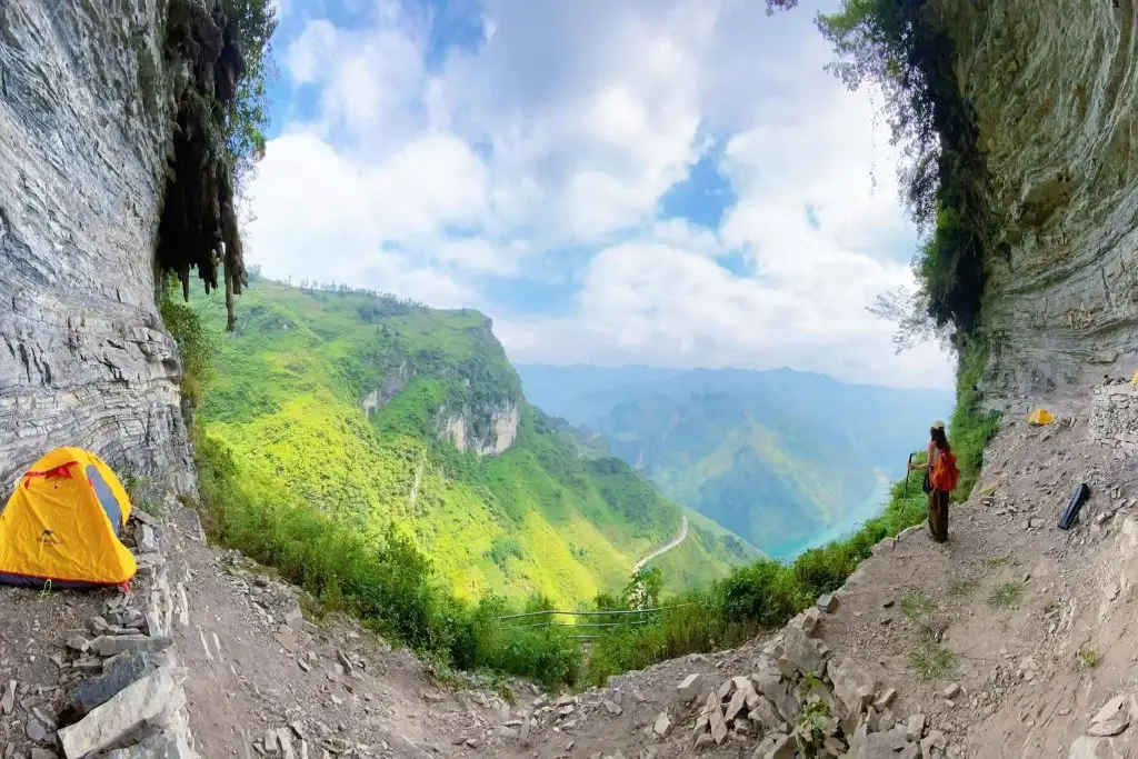Mountains view from cave entrance with hikers exploring the scenic landscape.