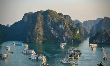 Halong Bay cruise ships sailing among limestone karsts.