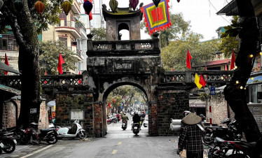 Hanoi old town gate with colorful lanterns and bustling street scene.