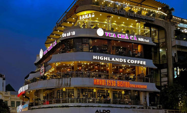 Highlands Coffee on a bustling street corner, vibrant evening atmosphere.