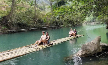 Hanoi river adventure with bamboo raft experience amidst lush greenery and tranquil waters.