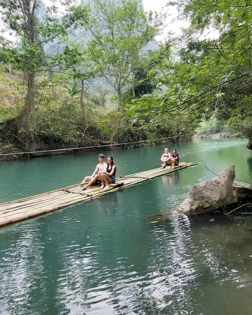 Hanoi river adventure with bamboo raft experience amidst lush greenery and tranquil waters.