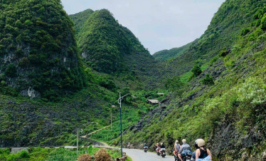Ha Long Bay scenic drive with lush green mountains and winding road.