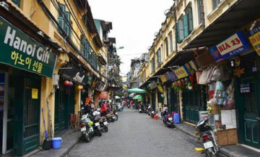 Hoi An street view with colorful shops and scooters, vibrant local atmosphere.
