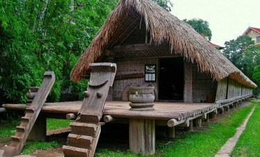 Traditional Vietnamese stilt house with thatched roof and wooden structure.