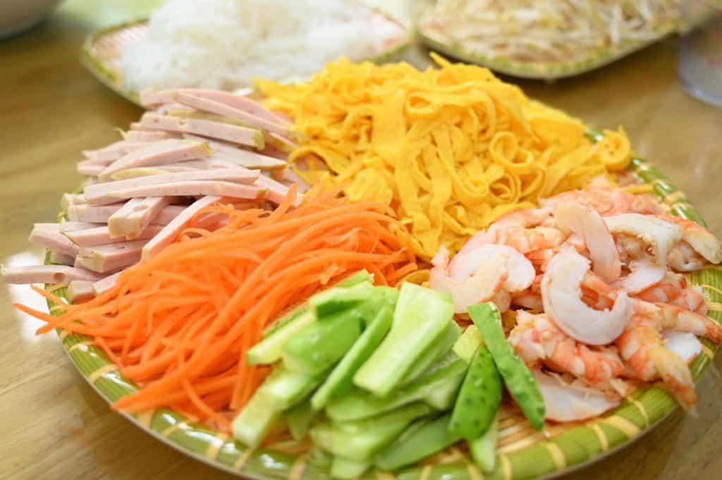 Fresh Vietnamese food platter with shrimp, vegetables, and noodles.