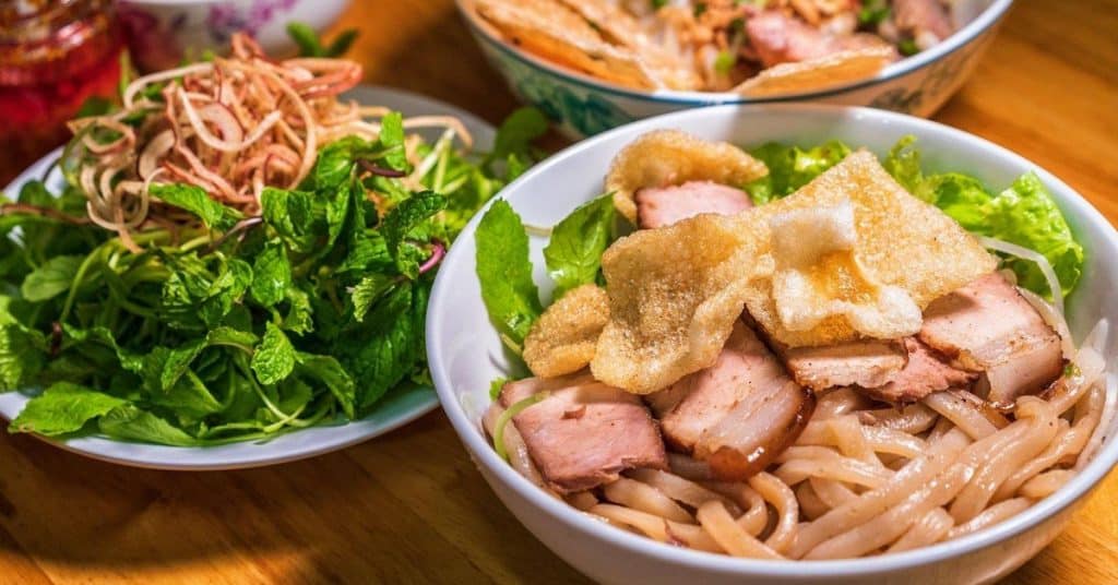 Vietnamese noodle and pork salad with fresh herbs and greens.