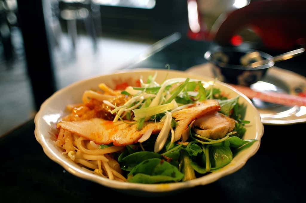Vietnamese noodle soup with fresh herbs and vegetables.