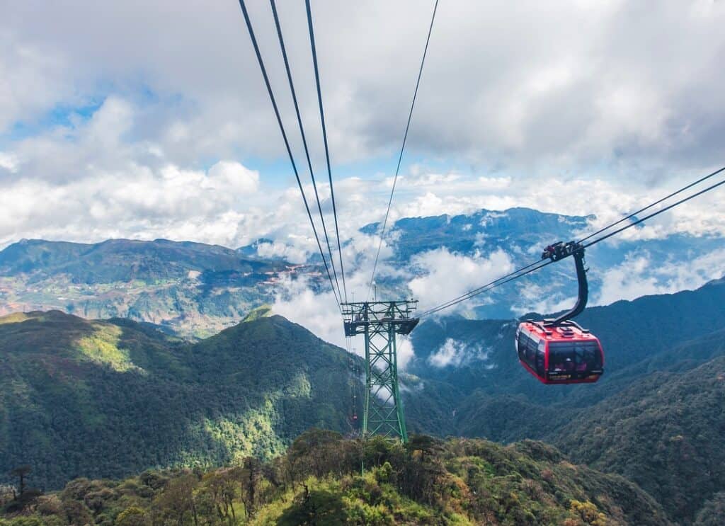 Cable car ascending over lush green mountains in Sapa, offering breathtaking scenery and a luxurious.