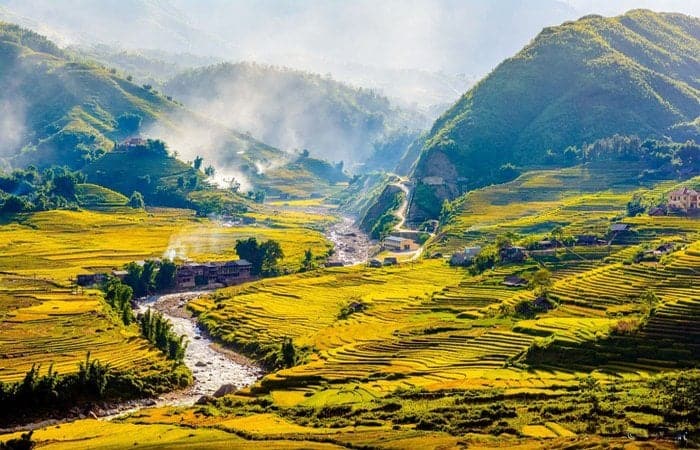 Scenic rice terraces in Sapa with lush green mountains and misty atmosphere.
