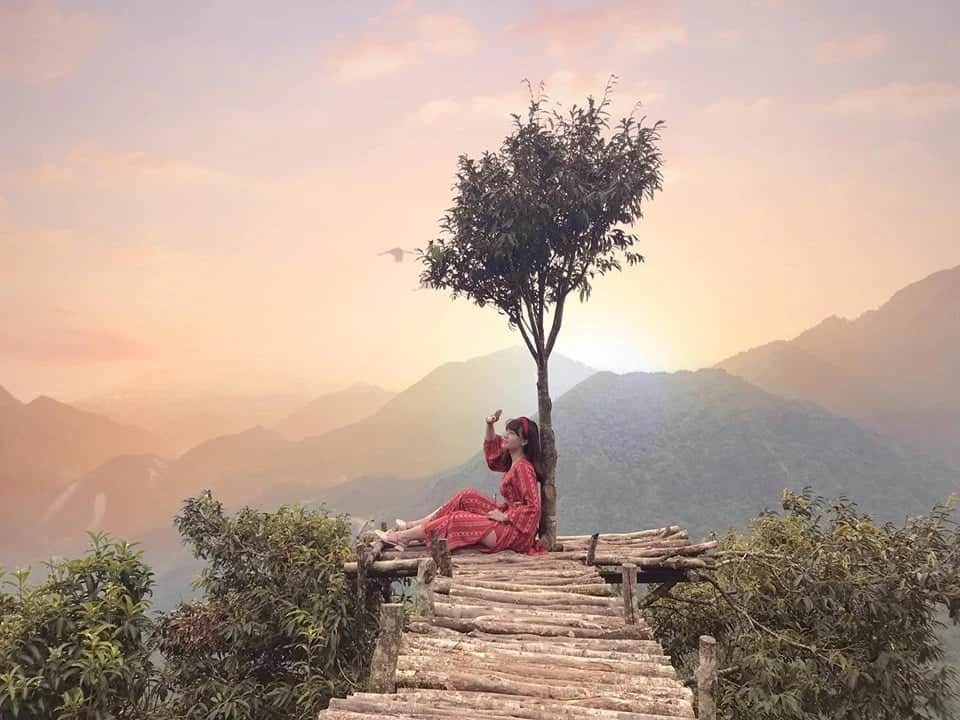 Sunset over Sapa's scenic landscape with a peaceful moment by a lone tree.