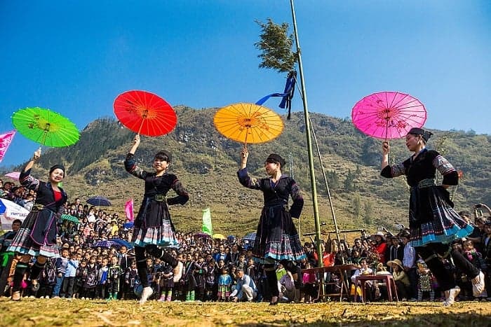 Traditional Sapa dance performance with colorful umbrellas and lively local costumes.