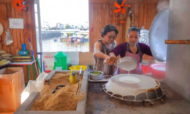 Mekong Delta women preparing traditional rice paper in a cozy local kitchen.