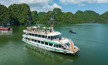 Serenity Cruise boat floating on tranquil Lan Ha Bay surrounded by lush green karst formations.