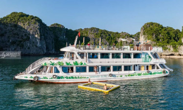 Serenity Cruise floating on tranquil Lan Ha Bay with stunning limestone karsts.
