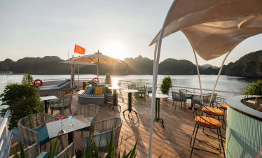 Relaxing deck with seating and scenic views of Lan Ha Bay at sunset, perfect for a luxurious escape.