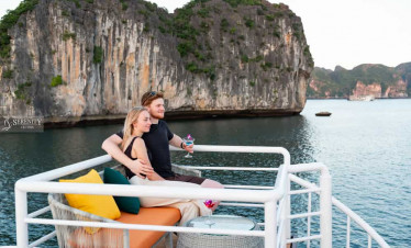 Relaxing on the deck of Serenity Cruise with stunning Lan Ha Bay scenery in the background.