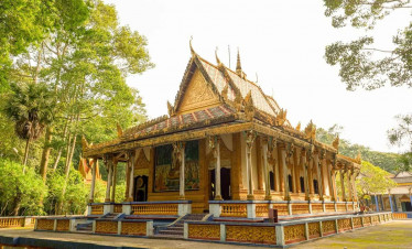 Mekong Delta temple with intricate architecture surrounded by lush greenery.