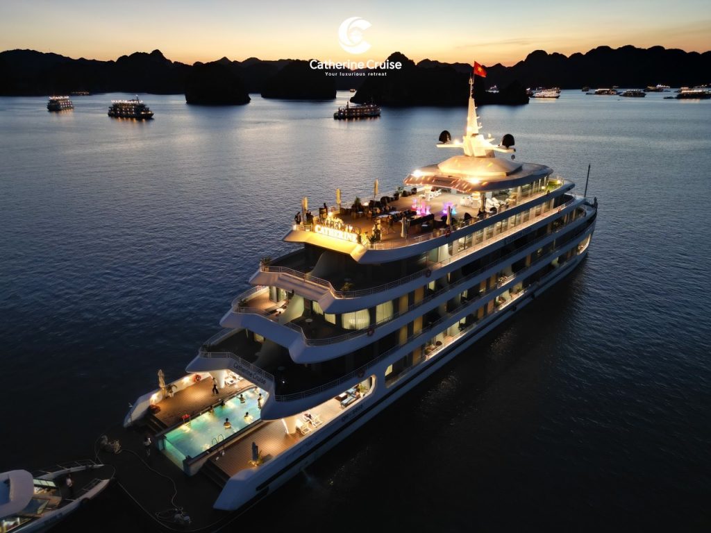 Luxurious yacht cruise at sunset in Ha Long Bay, Vietnam, offering elegant dining and sightseeing experiences.