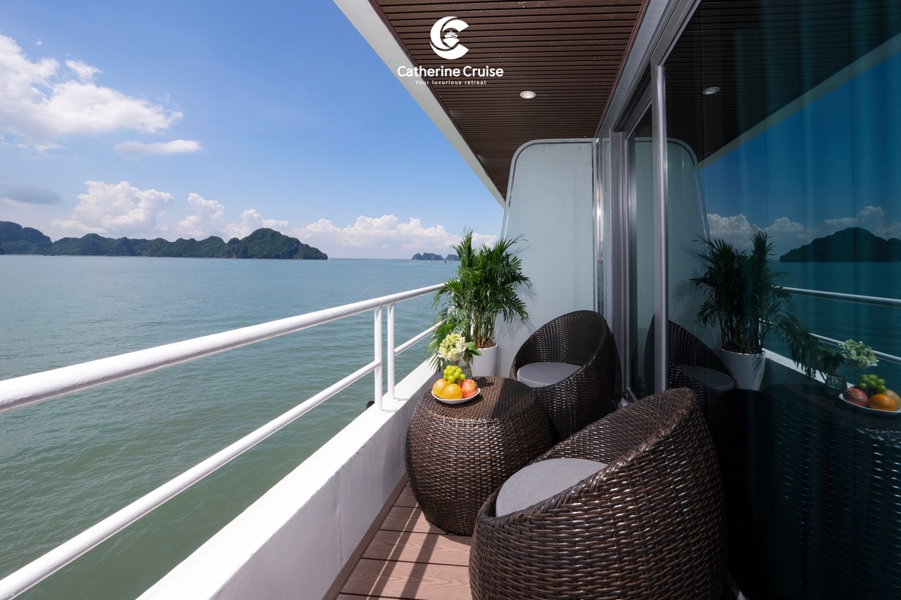 Stunning ocean view balcony on a luxury cruise ship with wicker chairs and plants.