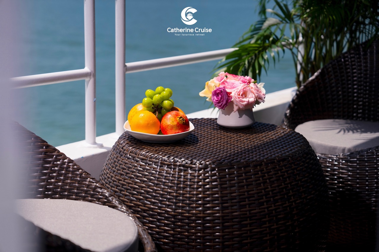 ViettrendTour luxury cruise deck with fresh fruits and floral decor overlooking the sea.