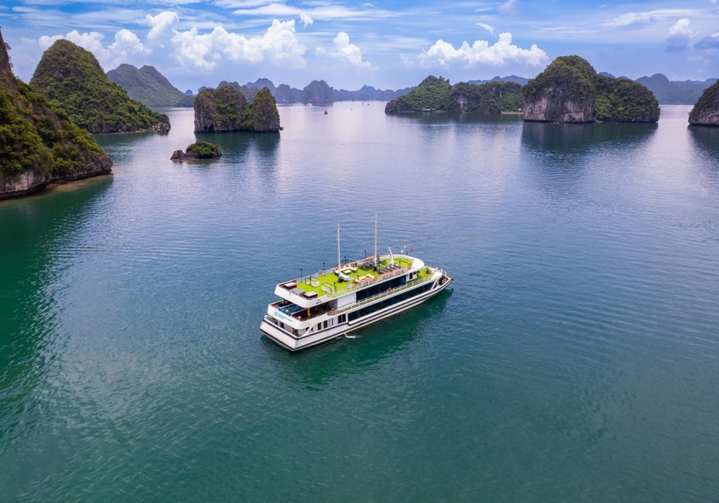 Aerial view of Heritage Cruise sailing through stunning limestone karsts in Halong Bay, Vietnam.