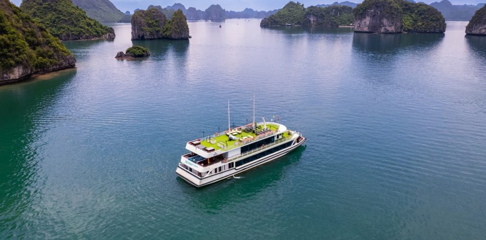 Aerial view of Heritage Cruise sailing through stunning limestone karsts in Halong Bay, Vietnam.
