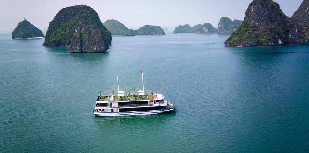 Beautiful Halong Bay landscape with a cruise boat sailing among limestone islands.