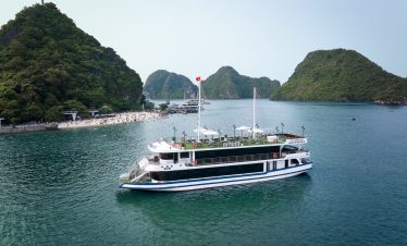 A luxurious cruise boat sailing through the stunning limestone karsts of Halong Bay, offering a rela.