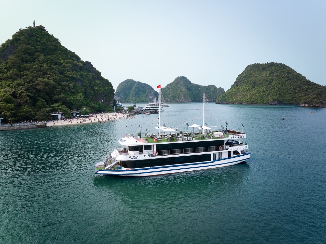 A luxurious cruise boat sailing through the stunning limestone karsts of Halong Bay, offering a rela.
