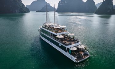 Halong Bay cruise boat sailing through emerald waters with limestone karsts, perfect for scenic expl.
