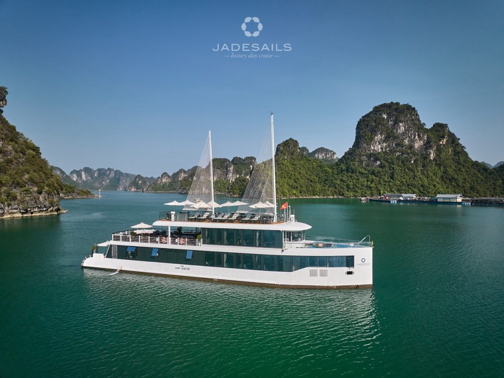 Elegant cruise boat sailing on Halong Bay with limestone karsts and clear waters.