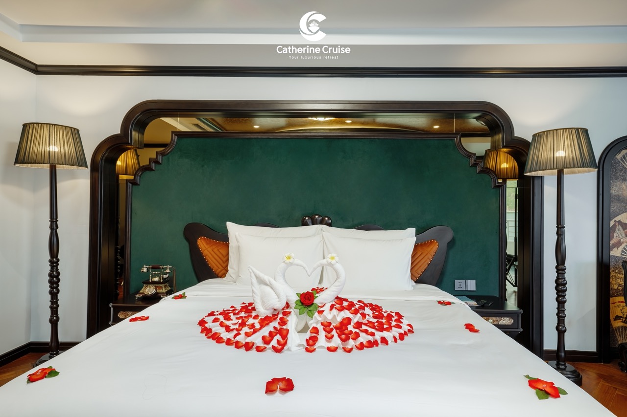 Romantic towel art with swans and rose petals on hotel bed at Catherine Cruise resort.