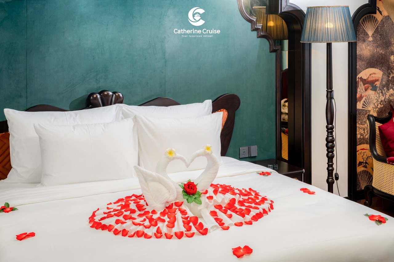 Romantic hotel room with swan towel art, rose petals, perfect for honeymoon or getaway.