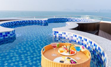 Stunning view of Halong Bay from a luxury cruise balcony with vibrant blue waters and scenic islands.